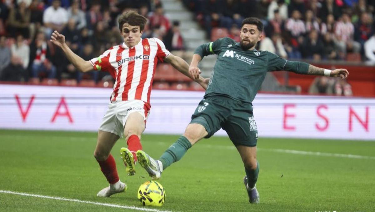 Jordi Escobar disputa un balón con Andrés Cuenca en El Molinón.