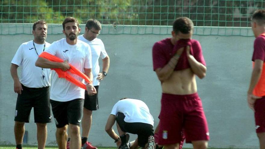 Víctor Fernández (izq.), entrenador del Cartagena, se coloca un peto durante un entrenamiento reciente.