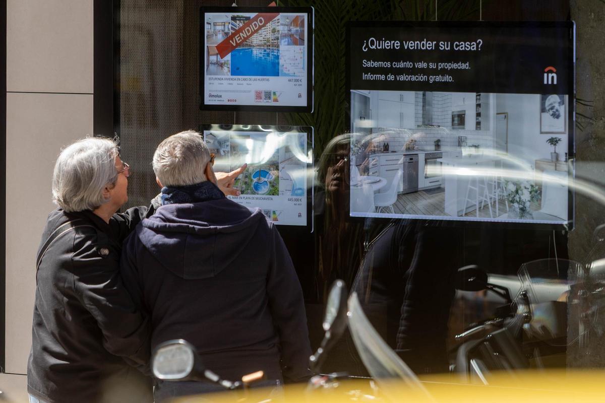 Dos personas consultando las ofertas de una inmobiliaria en Alicante.