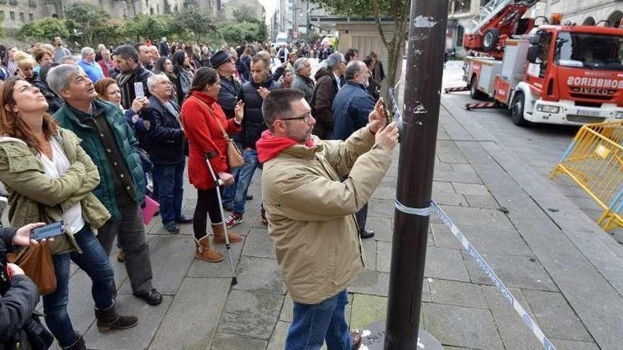 Cientos de pontevedreses fotografiaron el incendio y ayer (en la imagen) siguieron los trabajos de retirada de escombros de la fachada de La Moda Ideal. // Gustavo Santos