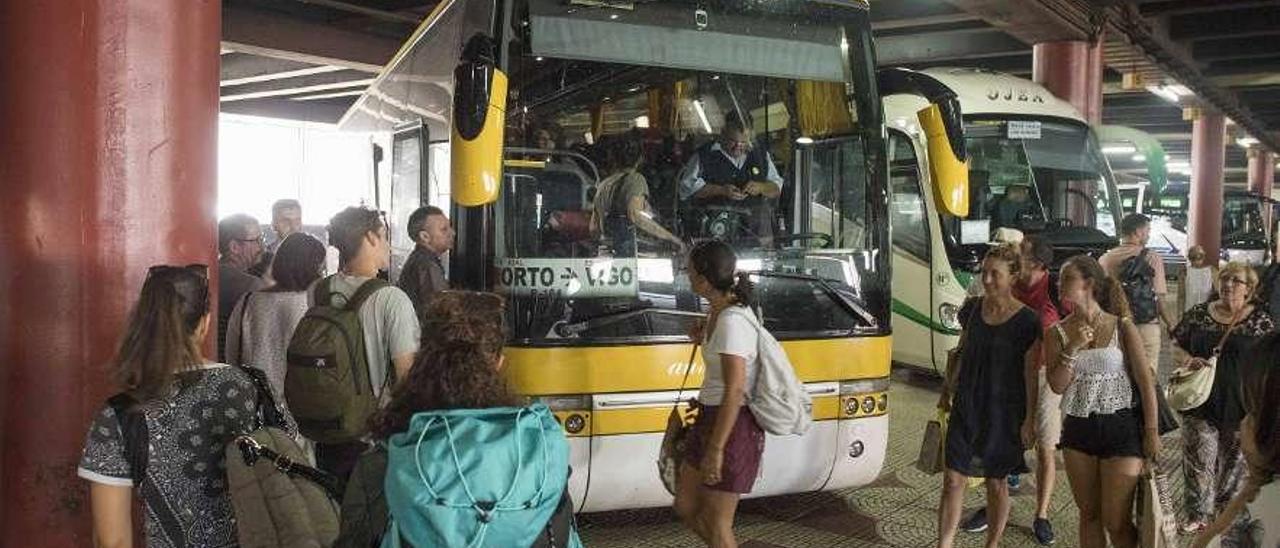 Un grupo de viajeros, ayer, subiéndose en la estación de Vigo a un autobús hacia Oporto. // Cristina Graña