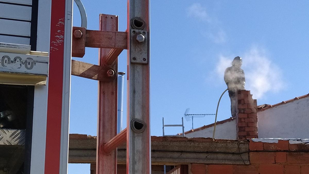 El bombero apaga el fuego surgido en la chimenea.