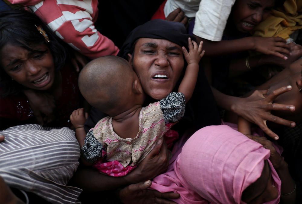 Rohingya refugees scuffle as they wait to ...