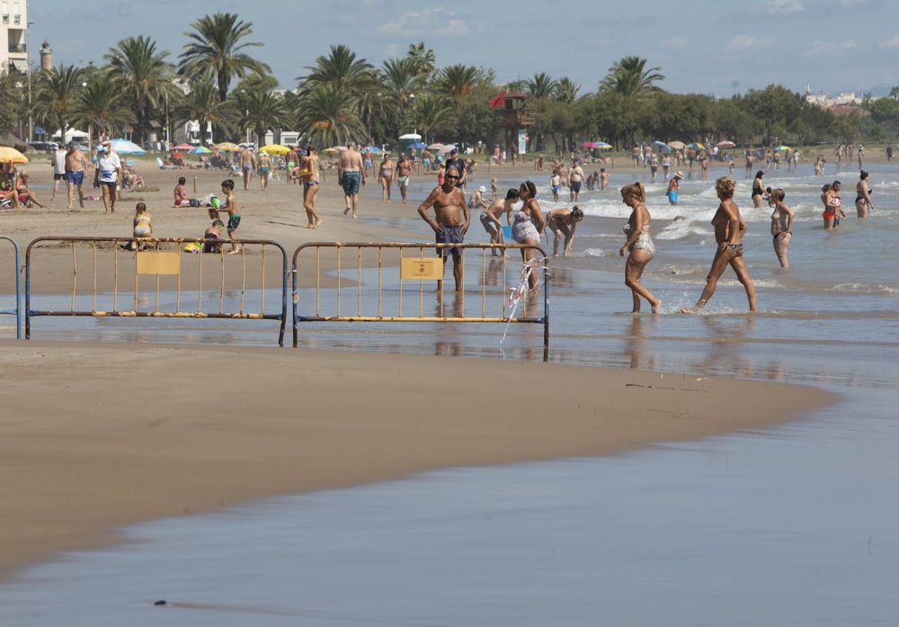 Contraste en la playa del Puerto de Sagunto, con una zona cerrada por los daños de las lluvias.