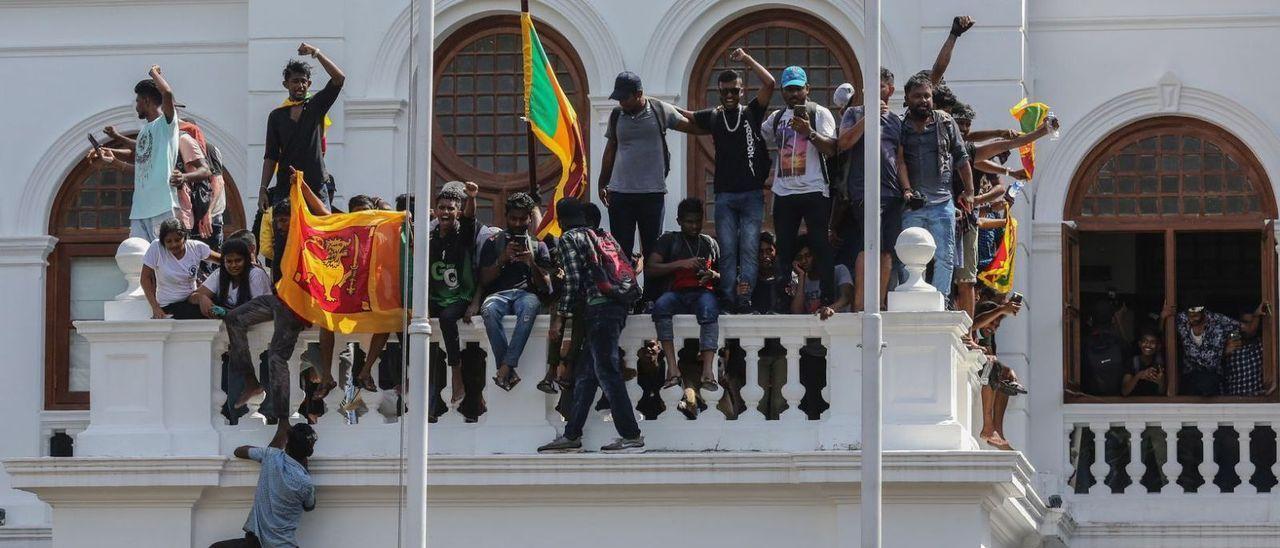 Manifestantes encaramados a la fachada del palacio del primer ministro de Sri Lanka, el día 13.