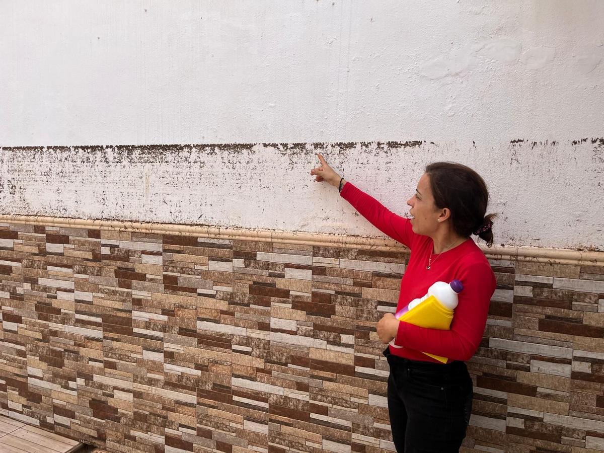 Katia indica el nivel hasta donde llegó el agua en su casa.