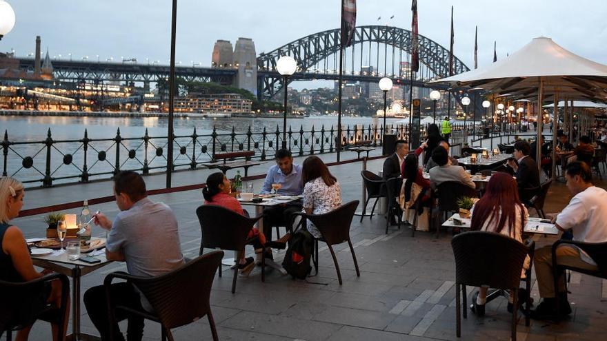 Varias personas cenan en la víspera de Año Nuevo en Sydney.