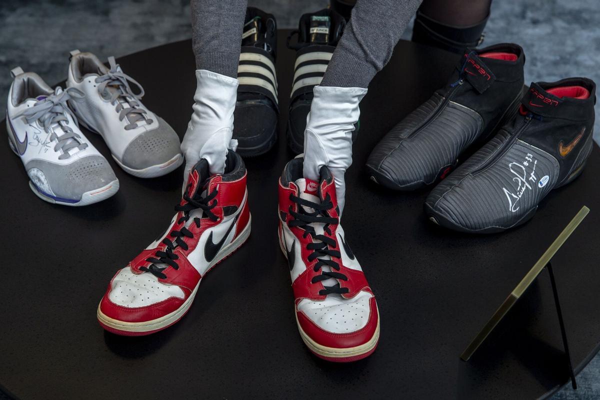 Geneva Geneve Genf (Switzerland Schweiz Suisse), 28/04/2021.- A person puts shoes of former NBA player Michael Jordan Game Worn 1985 Player Sample Air Jordan 1s estimated to sell between 100,000 to 150,000 Swiss francs (CHF) in front of shoes of formers NBA players Steve Nash, back left, Dual Signed Game Worn Zoom BB, Kevin Garnett, back center, Game Worn TS Bounce Commander, and Scottie Pippen, back right, Signed Game Worn Air Pippen V, during a Sotheby's preview at the boutique Buchere, in Geneva, Switzerland, 28 April 2021. Sotheby's presents 'Gamers Only', a selective online auction of game-worn sneakers from some of basketball's greatest athletes until 12 May. (Baloncesto, Jordania, Suiza, Ginebra) EFE/EPA/SALVATORE DI NOLFI. HORIZONTAL