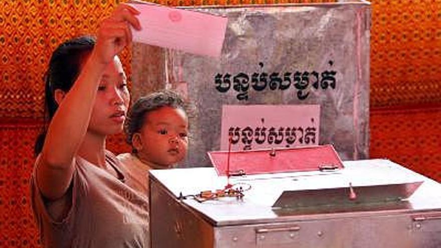 Una mujer camboyana vota en un colegio electoral de Phnom Penh (Camboya), durante los comicios en los que se escogerán a los 123 miembros del Parlamento nacional, y que apuntan hacia una abrumadora victoria del antiguo partido comunista Partido del Pueblo, que lidera el actual primer ministro, Hun Sen.