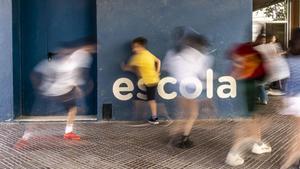 Menores juegan en el patio de la Escola Bogatell de Barcelona.