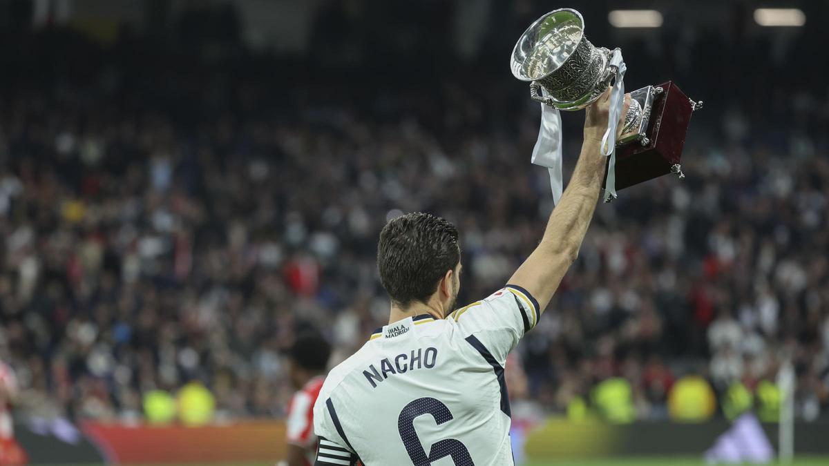 Nacho enseña a la grada del Bernabéu, antes del Madrid-Almería, la Supercopa ganada al Barça.
