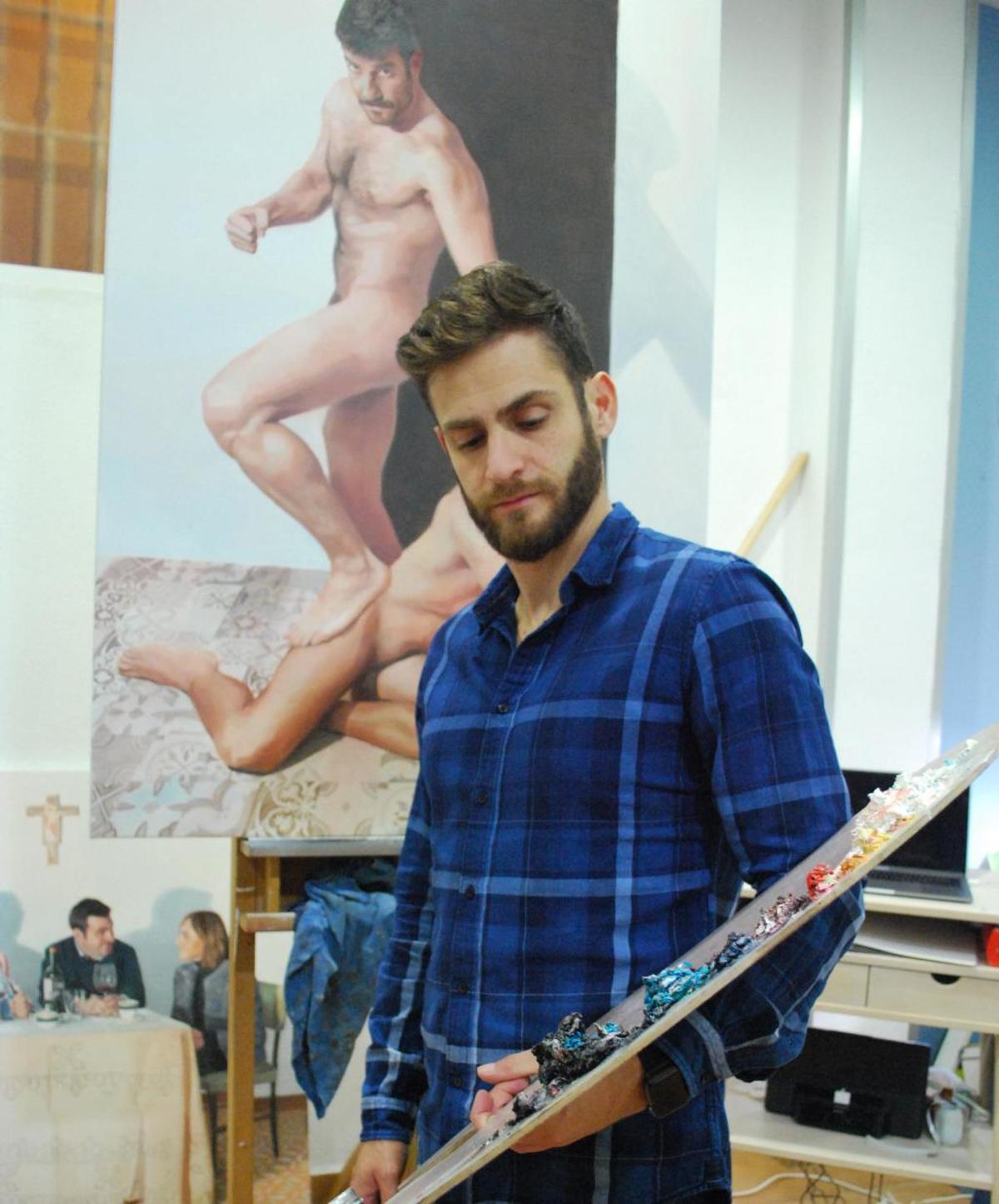 El artista Jean Carlos Puerto posa con sus pinturas