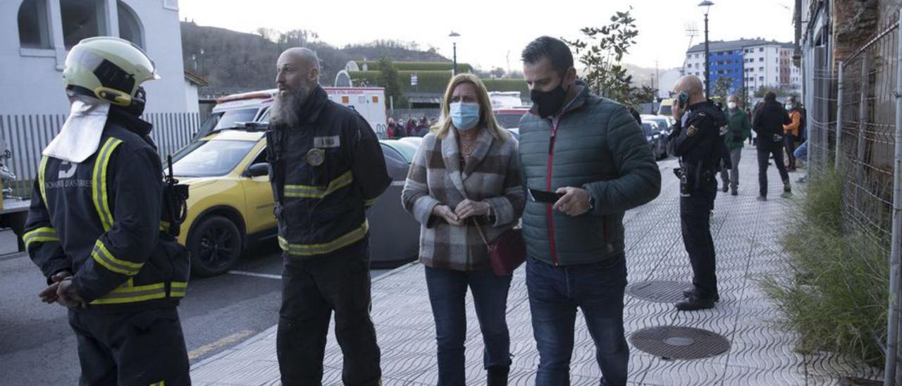 Carmen Arbesú y Javier Castro, junto a dos bomberos. | Miki López