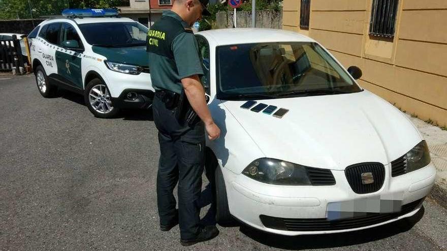 Un agente ante el vehículo en el que viajaban los detenidos. // Guardia Civil