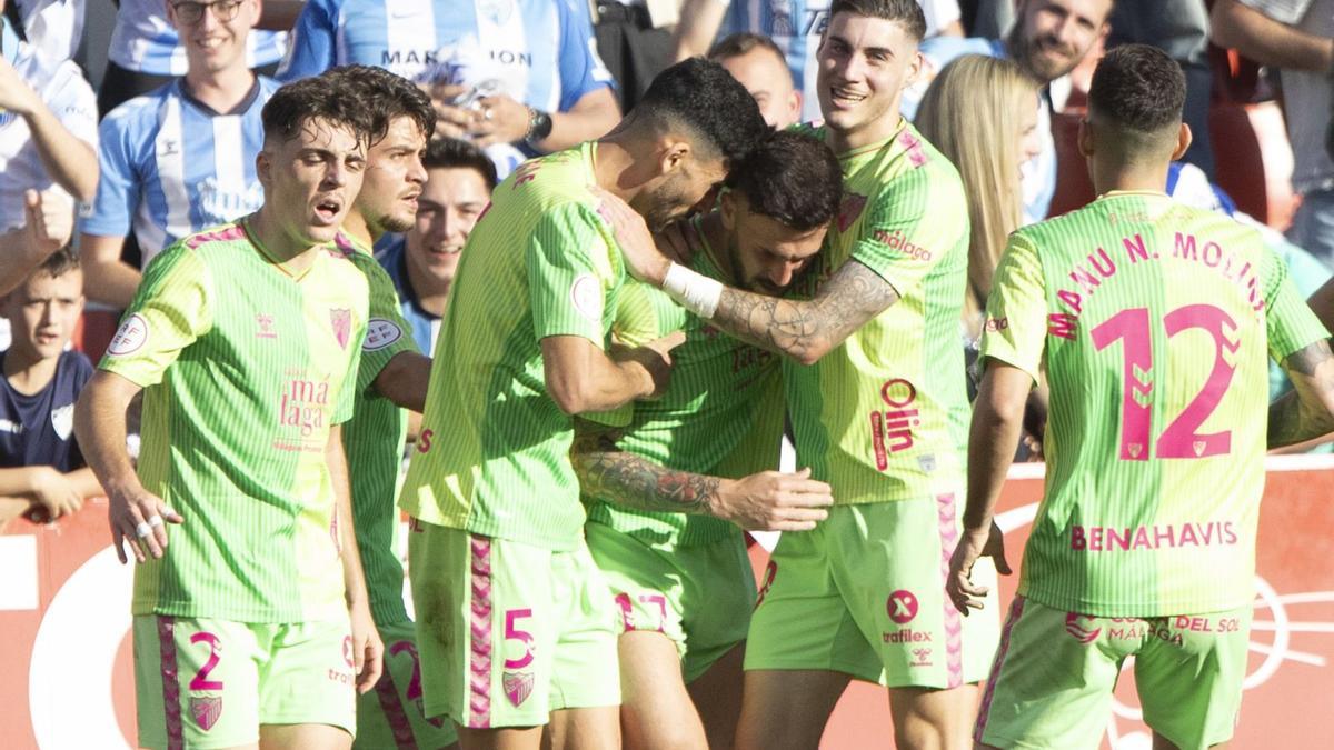 Los jugadores del Málaga CF celebran el gol de Dioni en el Nuevo Los Cármenes.