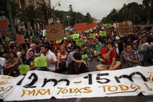 Demonstrators sit on a street as they march on the second anniversary of the 15M movement in Malaga