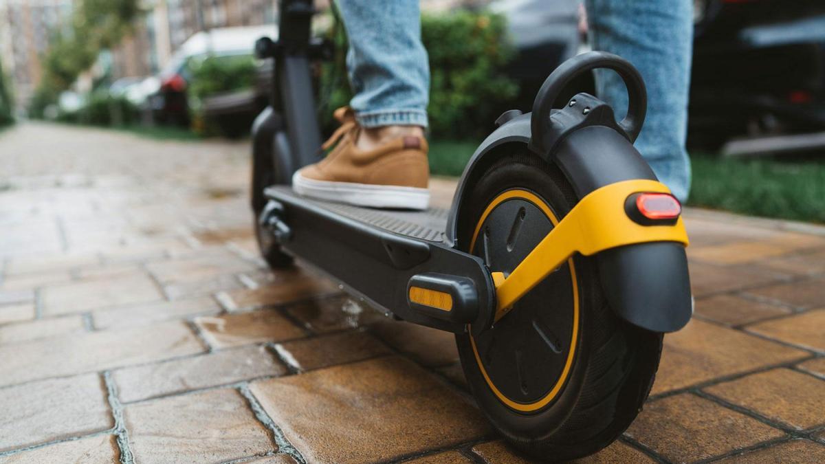 Persona encima de un patienete eléctrico