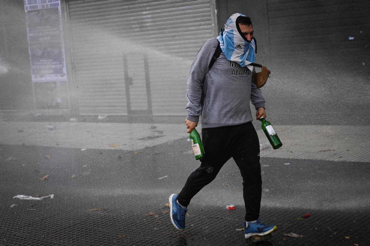 Manifestantes chocan con la policía antidisturbios frente al Congreso Nacional en Buenos Aires el 12 de junio de 2024. Los senadores argentinos debaten un paquete de reformas clave para el presidente ultraderechista Javier Milei, en una sesión marcada por huelgas y manifestaciones frente al Congreso.