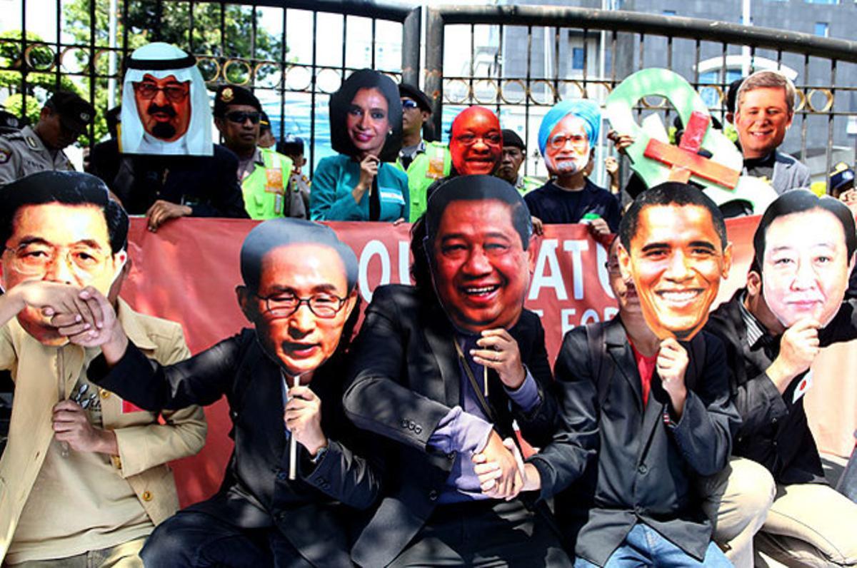 Activistes indonesis marxen amb una pancarta on es llegeix ’La nostra naturalesa no està a la venda’ i llueixen màscares de diversos dels líders que participen en la cimera del G-20, que se celebra a Jakarta.