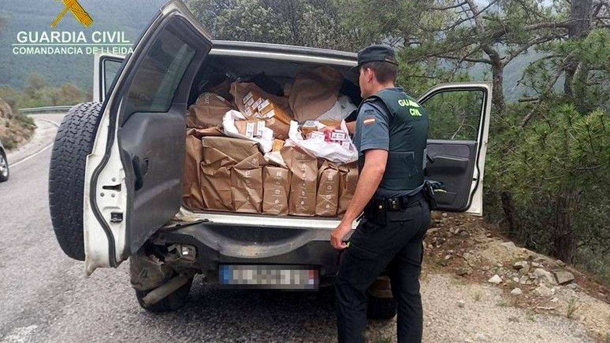 Un agent de la Guàrdia Civil mostra el maleter d&#039;un totterreny on han trobat més de 5.300 paquets de tabac contraban