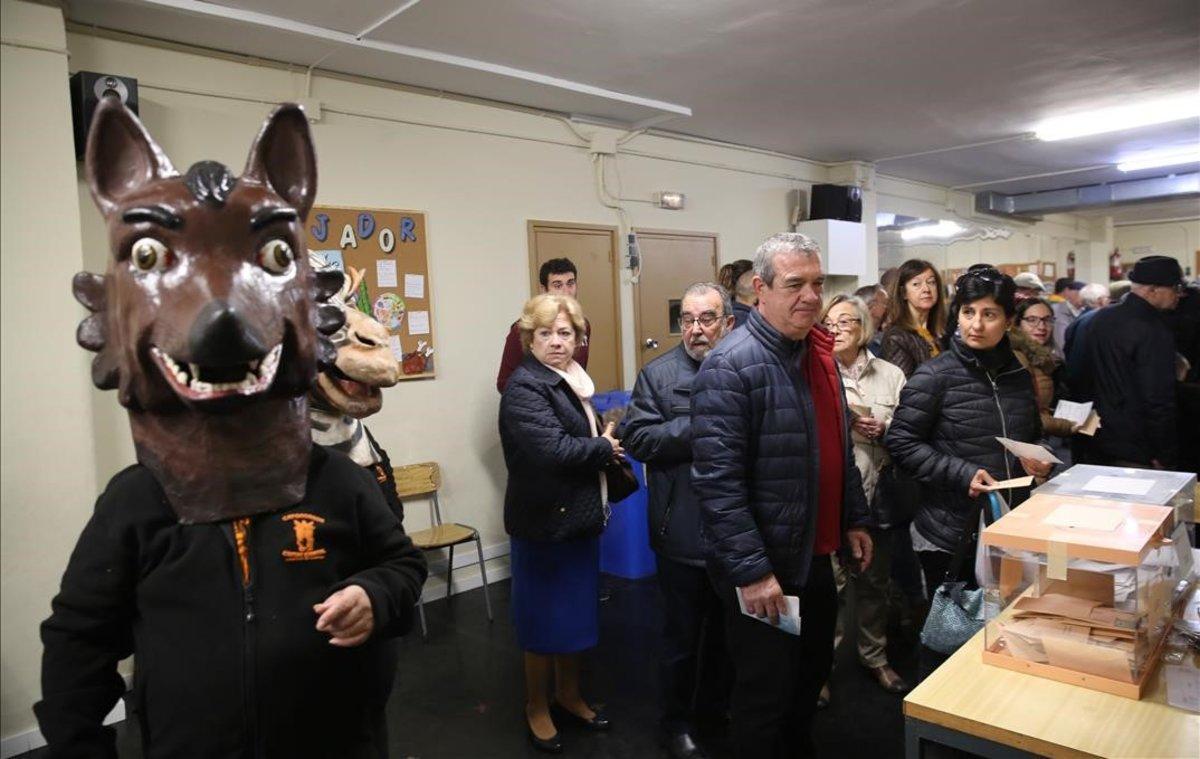 Votaciones en el colegio Santa Marta de L’Hospitalet de Llobregat. En la imagen, un lobo cabezudo de la Fiesta de la Primavera en la ciudad, en la sala donde se depositan los votos. 