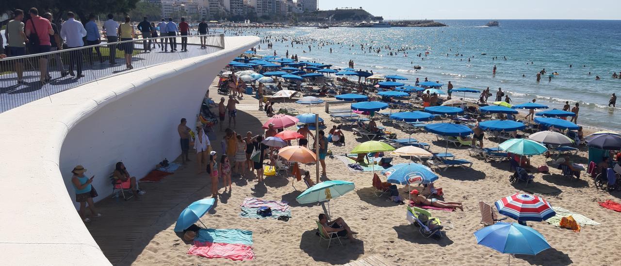 La pasarela de Poniente de Benidorm se llena de bañistas buscando la sombra.