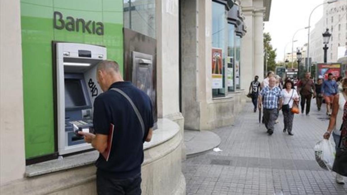 Usuarios de un cajero de Bankia en plaza Catalunya.