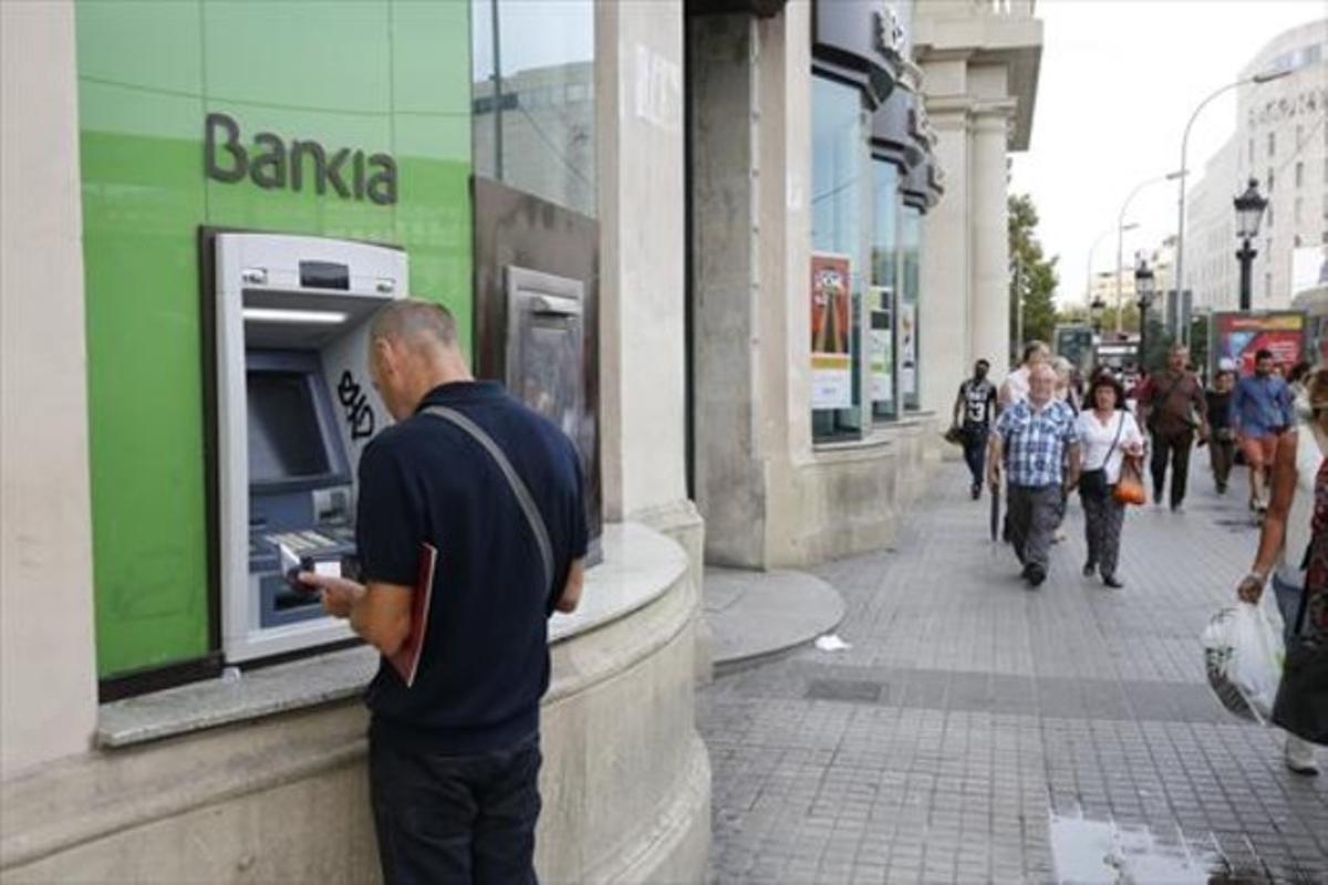 Usuari d’un caixer de Bankia a la plaça de Catalunya.