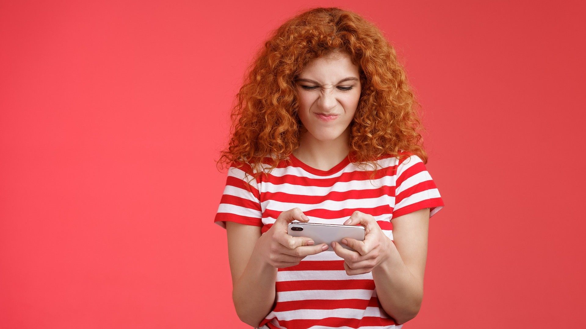 Una chica juega con su teléfono móvil