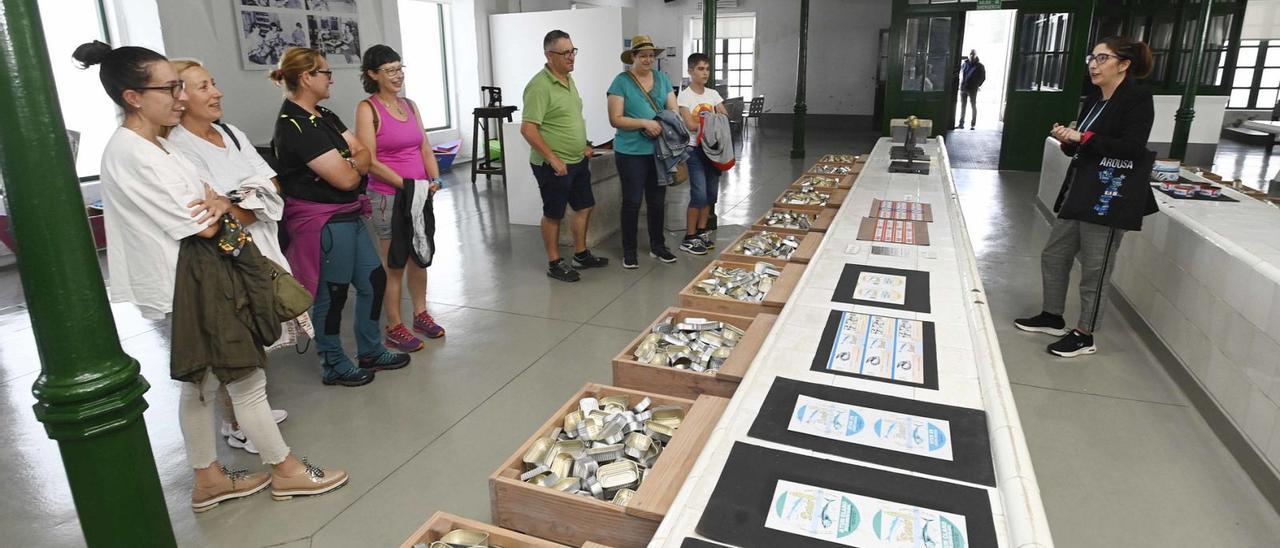 La téncica de turimso, Ana Millán, explica a los visitantes la historia de la fábrica de Goday y d ela conserva en A Illa.