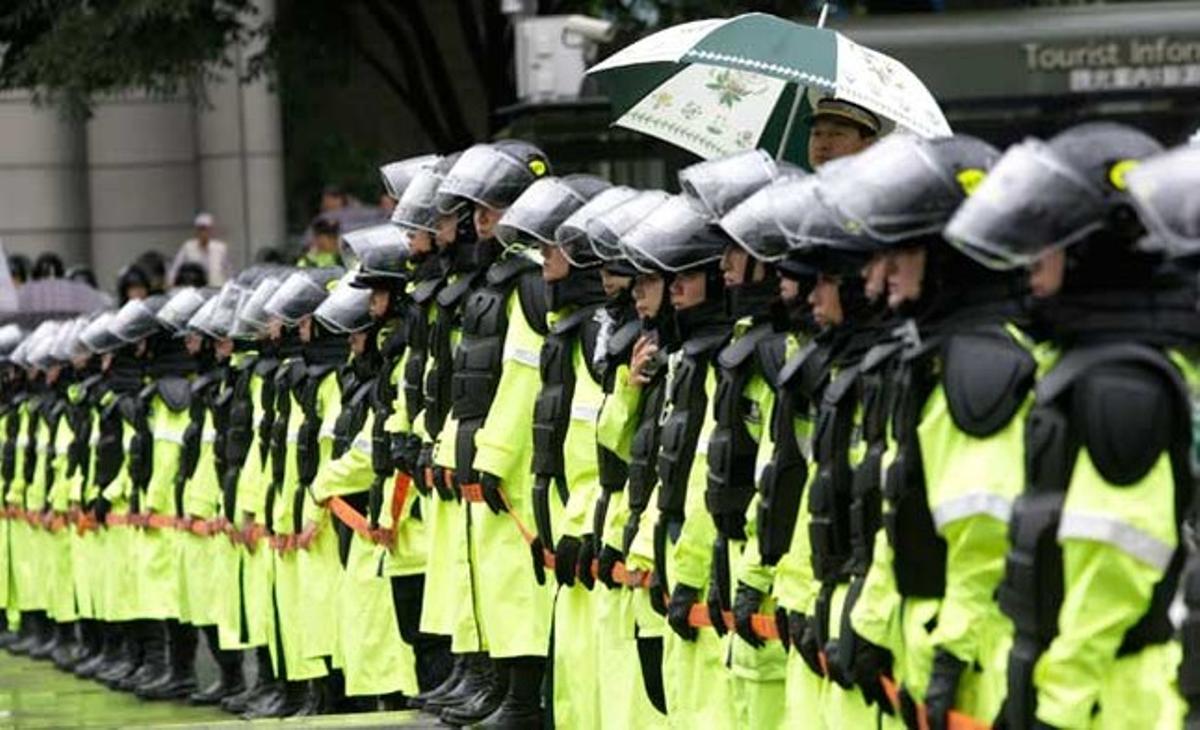 Un grup d’agents de la policia de Corea del Sud intenten bloquejar una manifestació contra la política econòmica del govern a Seül.