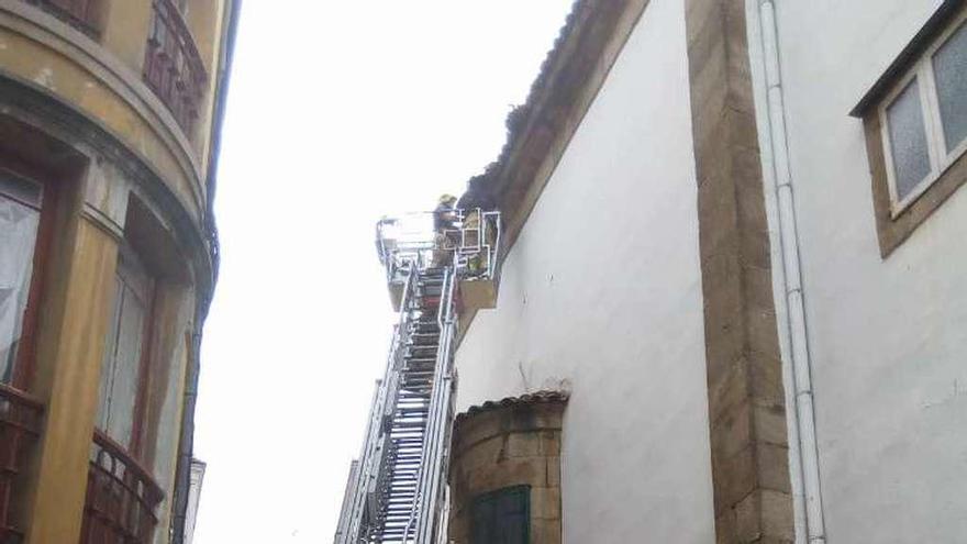 Los bomberos retiran parte de la cornisa de la iglesia de San Nicolás