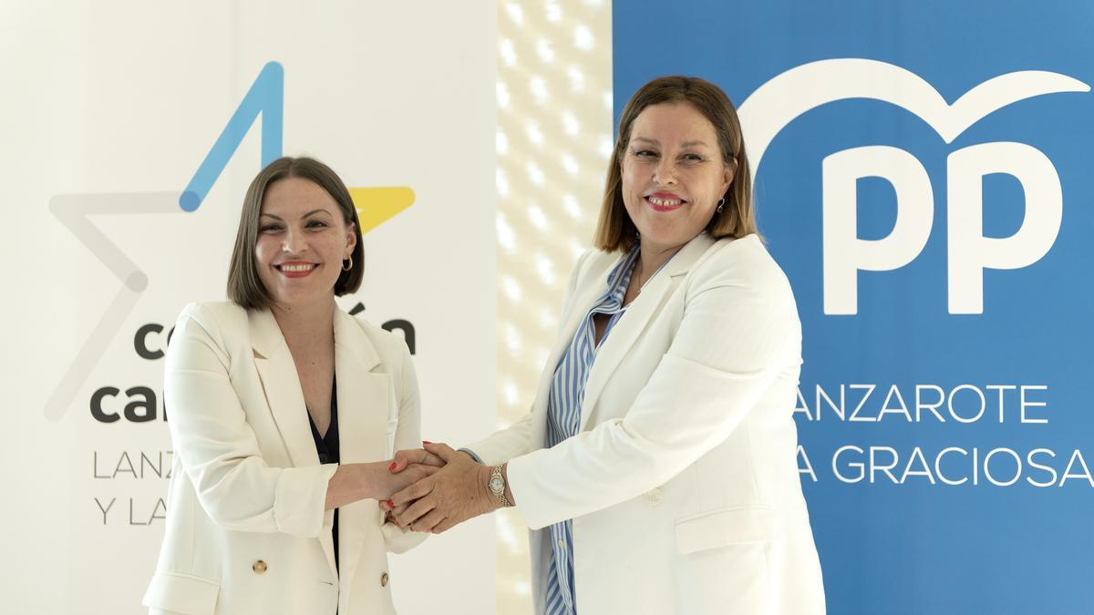Migdalia Machín (i) y Astrid Pérez sellan el acuerdo para gobernar en el Cabildo de Lanzarote y el Ayuntamiento de Arrecife a la espera de Teguise.