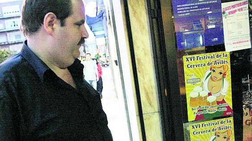 Un hombre observa el cartel del festival cervero, ayer, en la calle de José Cueto.