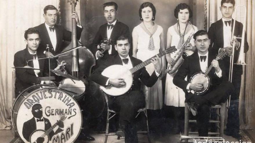 Joan Marí Juan tocava el contrabaix; els fills: Juanito, la bandúrria; Frederic, el banjo; Lluís, la bateria; Ferran el trombó; Antònia, el piano; Vicentai Magdalena el saxòfon i Manel, la trompeta.