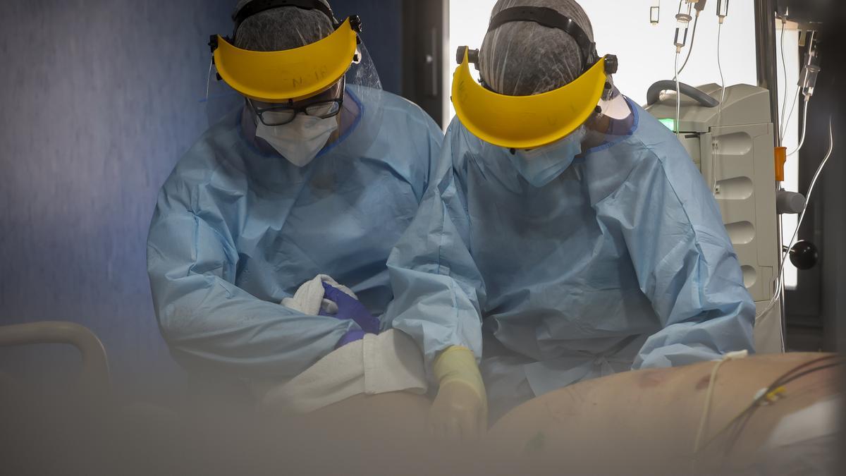 Dos sanitarios atendiendo a un paciente con covid en la UCI del Hospital San Joan