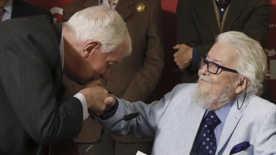 El director del Instituto Cervantes besa la mano de Del Paso.