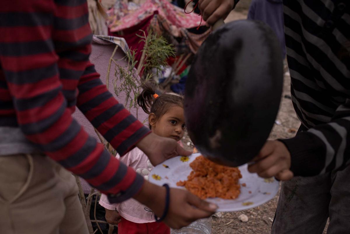 Migrantes acampan a lo largo de la orilla del río Grande mientras esperan entregarse a las autoridades de inmigración en El Paso, Texas, EE.UU