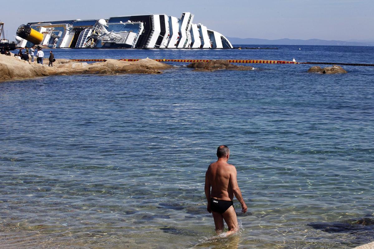 Un turista va a nadar con los restos del naufragio, el 9 de abril de 2012.