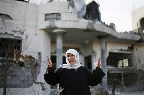 A Palestinian woman cries in front of a house damaged in an Israeli air strike in Beit Hanoun in the northern Gaza Strip