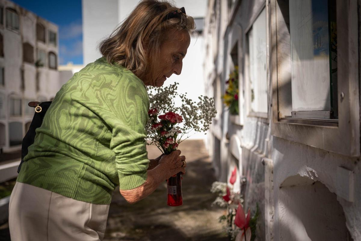Una mujer pone flores en un nicho.