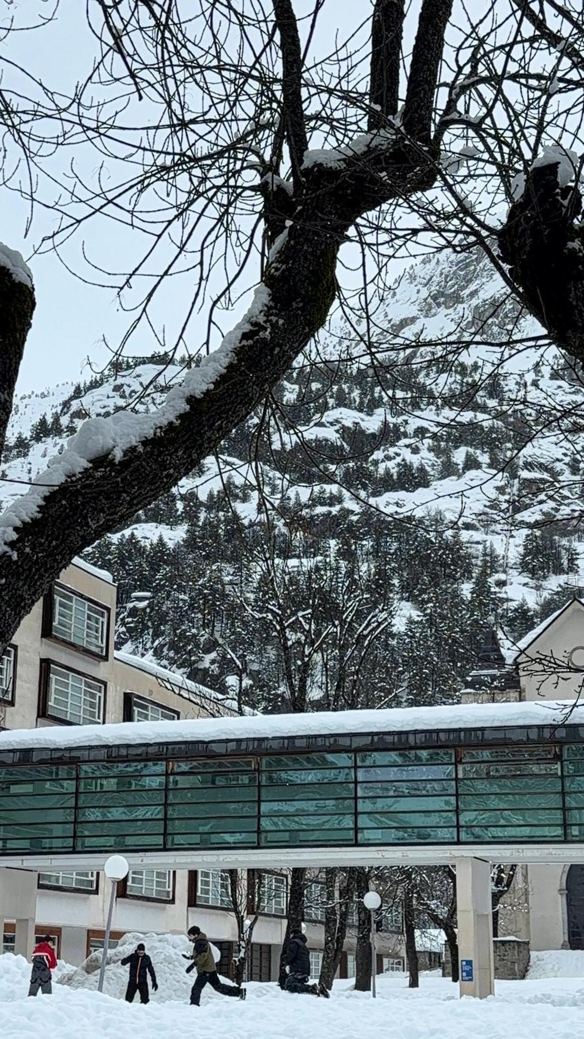 Cuatro niños juegan con la nieve en el exterior del balneario de Panticosa.