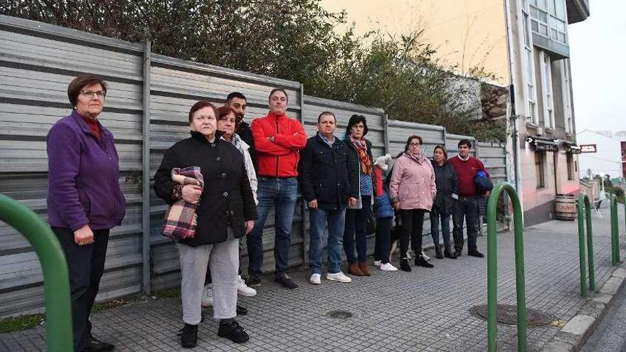 Vecinos de los edificios 52-54-56 de O Birloque, ante el solar abandonado contiguo a sus viviendas.