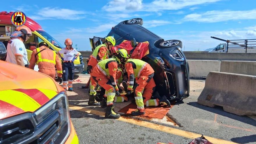 Los bomberos rescatan a una persona atrapada en un vehículo volcado en Montortal