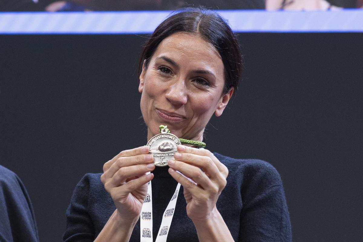 La actriz Itziar Miranda muestra su medalla tras ser nombrada miembro de la cofradía gastronómica de la trufa negra de Teruel, durante la subasta de Trufa este madres en Madrid Fusion.