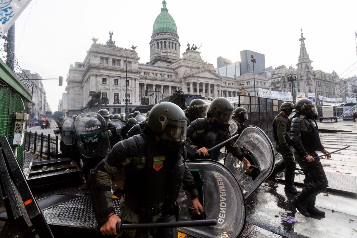 Manifestantes chocan con la policía antidisturbios frente al Congreso Nacional en Buenos Aires el 12 de junio de 2024. Los senadores argentinos debaten un paquete de reformas clave para el presidente ultraderechista Javier Milei, en una sesión marcada por huelgas y manifestaciones frente al Congreso.