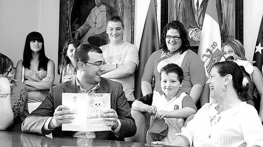 Adrián Barbón y María Gloria Fernández, con varios niños, durante la presentación del plan de infancia.