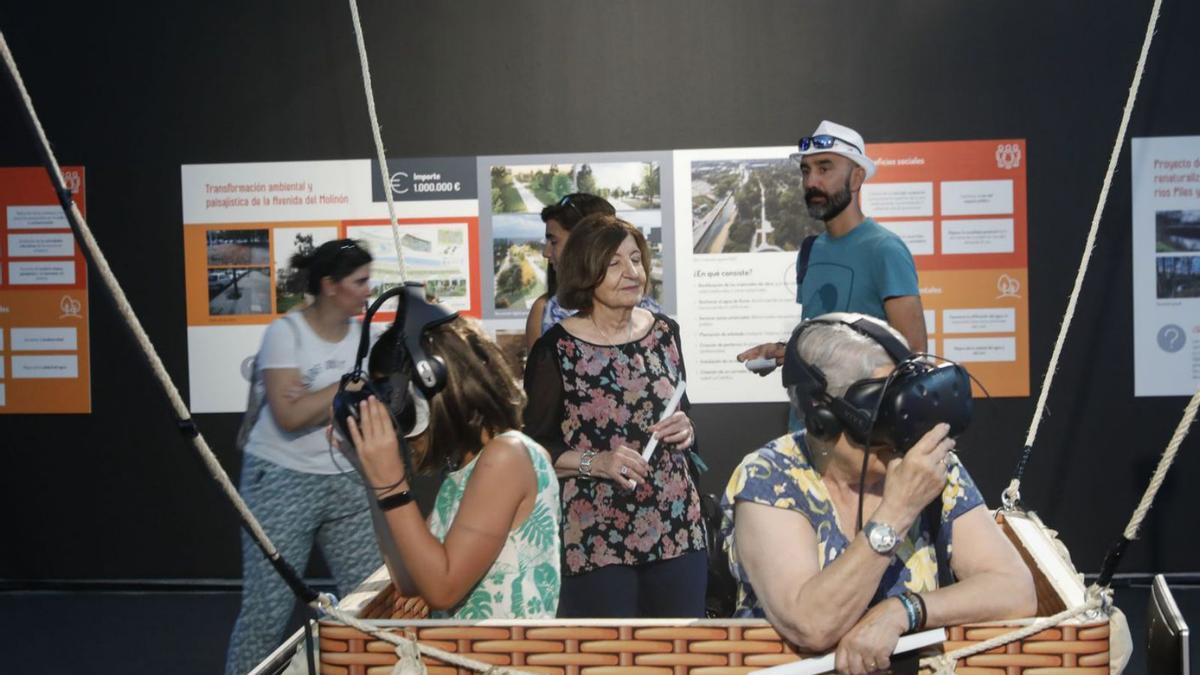 Dos visitantes disfrutan de una actividad de realidad virtual en el pabellón del Ayuntamiento de Gijón. | Marcos León