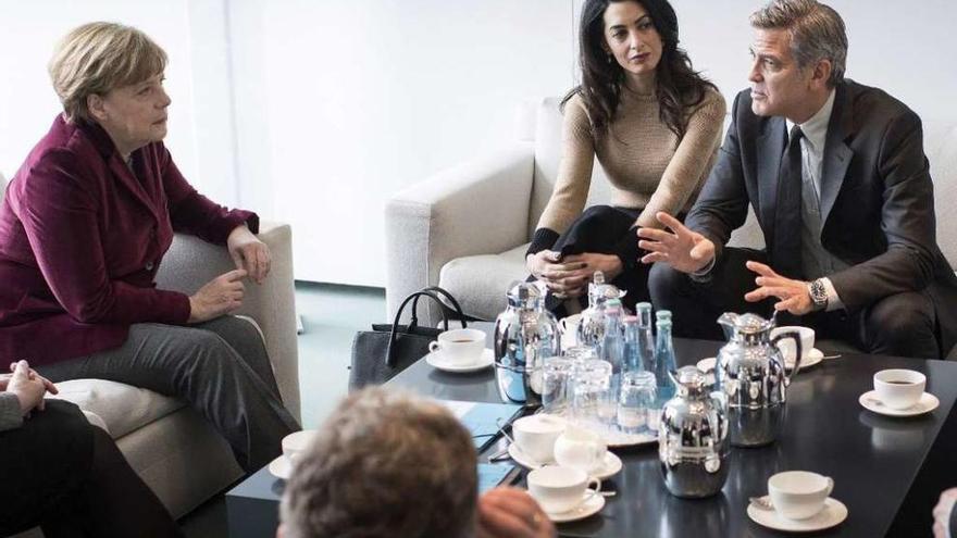 La canciller alemana, Angela Merkel, ayer, en su reunión con George Clooney y su mujer Amal.