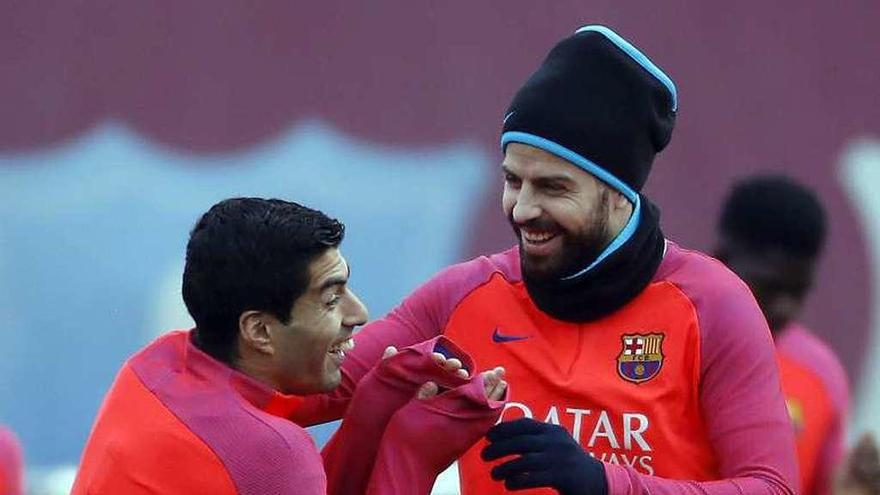 Suárez y Piqué bromean durante el entrenamiento de ayer. // Efe